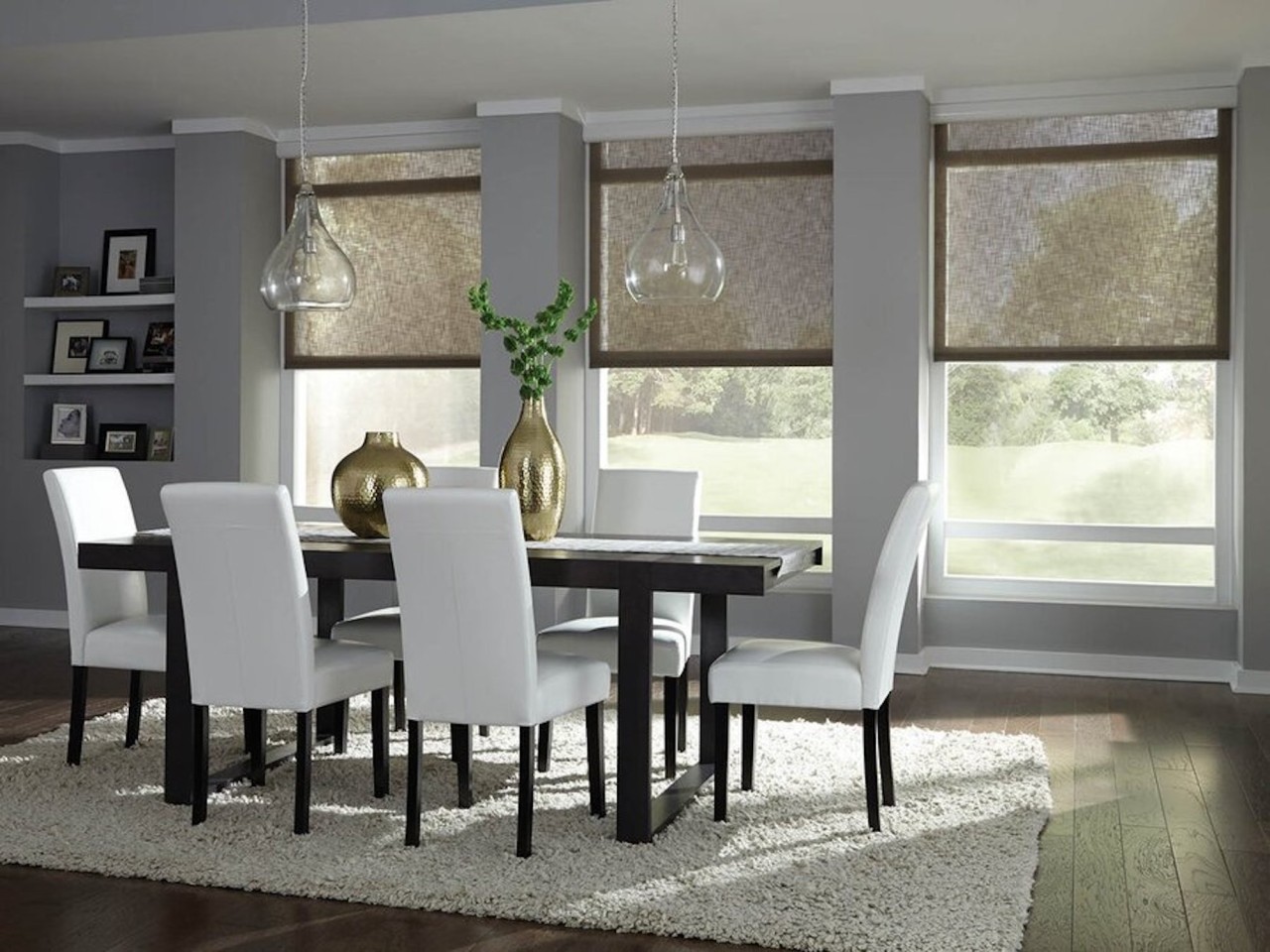 A dining table with windows in the background featuring Lutron motorized shades.