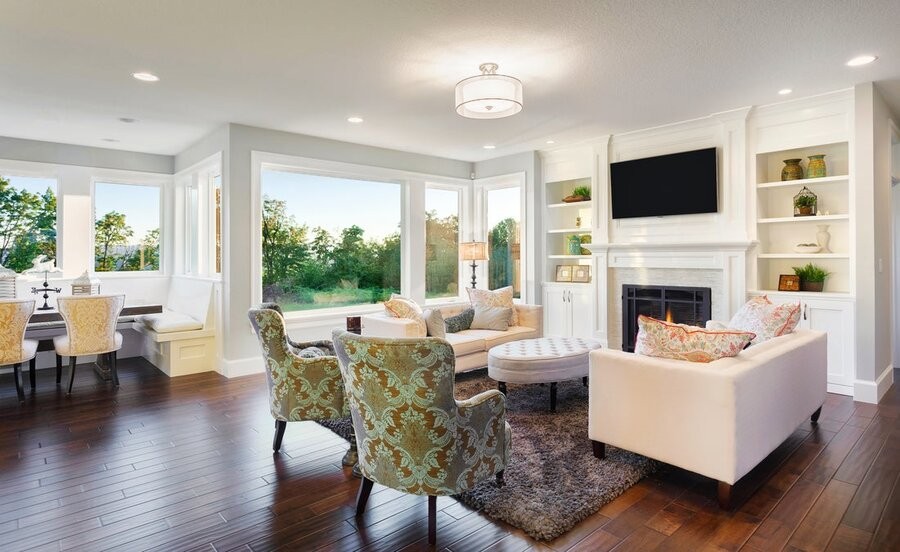An open living space featuring a family room setting with wide windows to the left.
