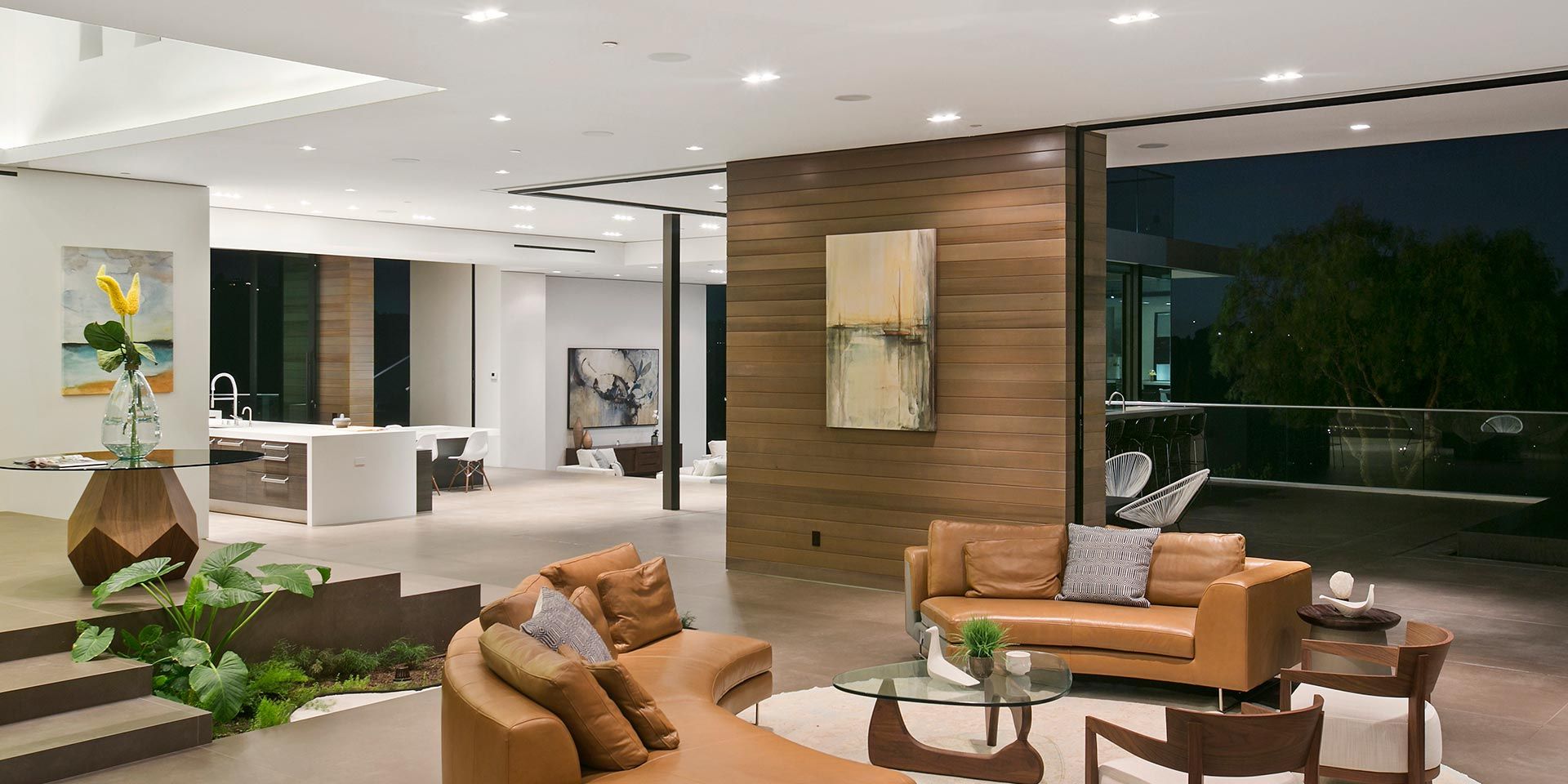 A spacious and elegant open-concept living room with modern furniture, large windows, and contemporary decor.