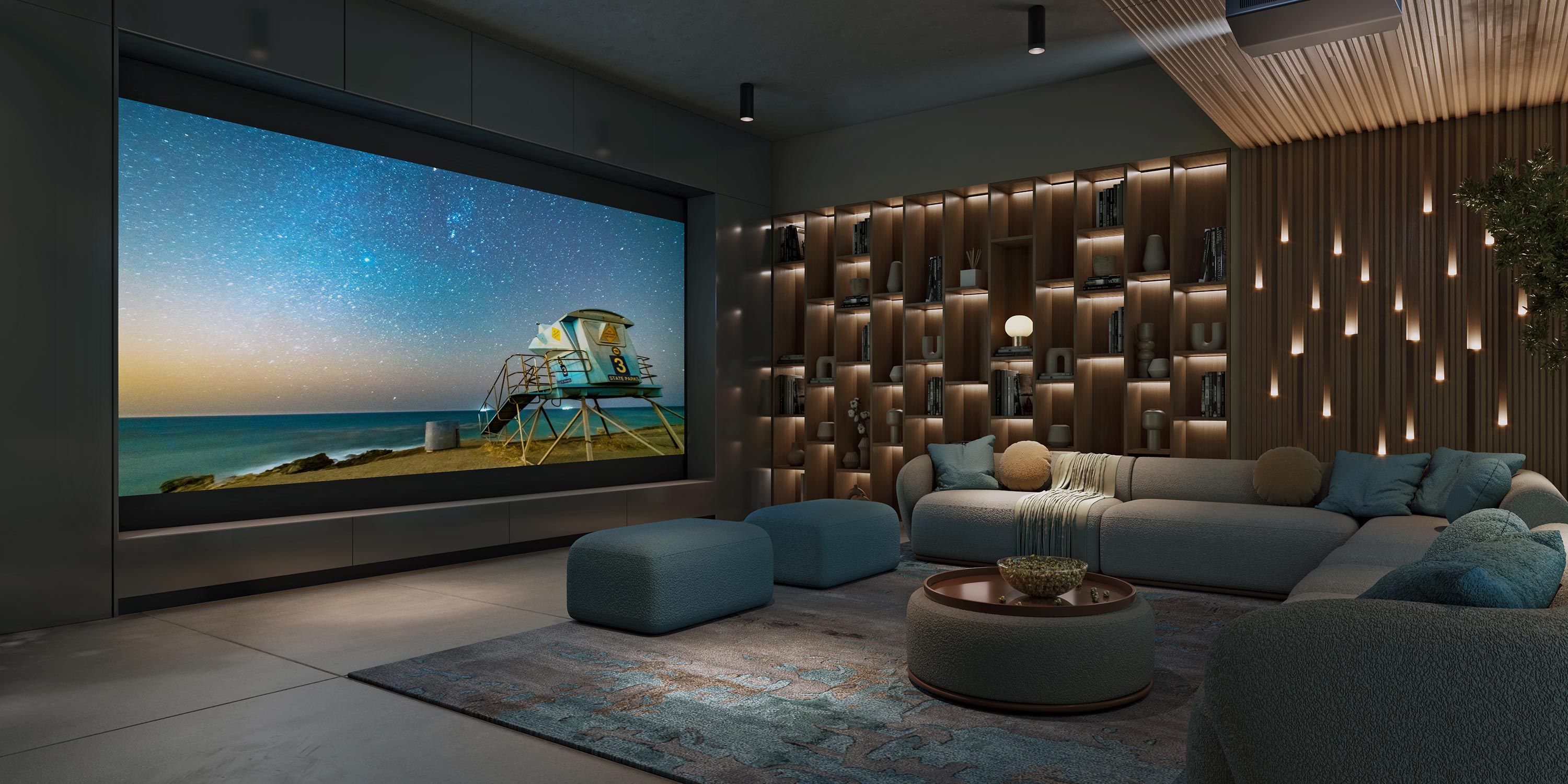 A cozy home theater with a large screen displaying a lifeguard tower on a beach at sunset, surrounded by comfortable seating and stylish shelving with decorative items.